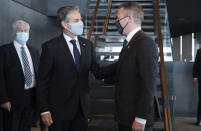 Icelandic Foreign Minister Gudlaugur Thor Thordarson, centre right, greets US Secretary of State Antony Blinken as he arrives for meetings at the Harpa Concert Hall in Reykjavik, Iceland, Tuesday, May 18, 2021. Blinken is touting the Biden administration's abrupt shift in its predecessor's climate policies as he visits Iceland for talks with senior officials from the world's Arctic nations. (Saul Loeb/Pool Photo via AP)