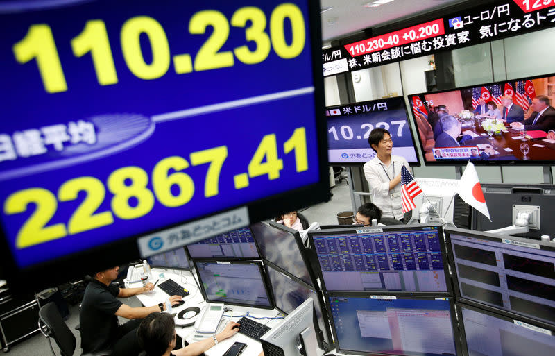 Employees of a foreign exchange trading company work near monitors broadcasting TV news reporting from the summit between the U.S. and North Korea (R) and the Japanese yen's exchange rate against the U.S. dollar and Nikkei share average in Tokyo, Japan, June 12, 2018. REUTERS/Issei Kato