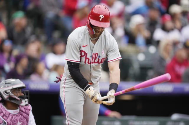 Philadelphia Phillies' Bryce Harper, right, reacts after flying out against Colorado Rockies starting pitcher Kyle Freeland in the third inning of a baseball game Sunday, May 14, 2023, in Denver. (AP Photo/David Zalubowski)