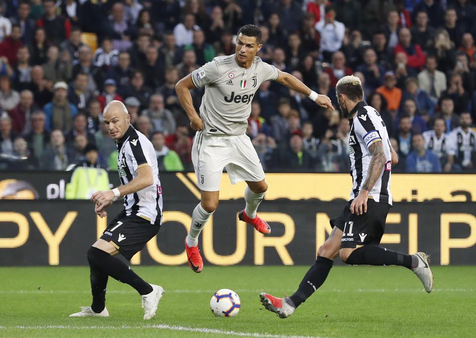 Juventus's Cristiano Ronaldo, center, challenges for the ball with Udinese’s Valon Behrami, right, and his teammate Giuseppe Pezzella during the Serie A soccer match between AC Udinese and Juventus at the Dacia Arena Stadium, in Udine, Italy, Saturday, Oct. 6, 2018. (AP Photo/Antonio Calanni)