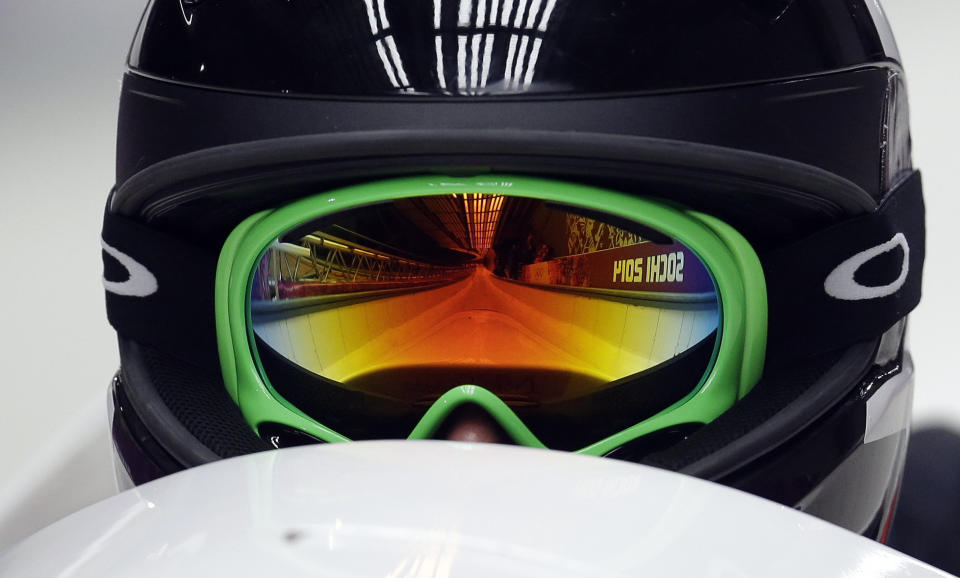 The track is reflected in the goggles of Canada's CAN-2 pilot Jennifer Ciochetti as she starts their first run during the women's two-man bobsled competition at the 2014 Winter Olympics, Tuesday, Feb. 18, 2014, in Krasnaya Polyana, Russia. 