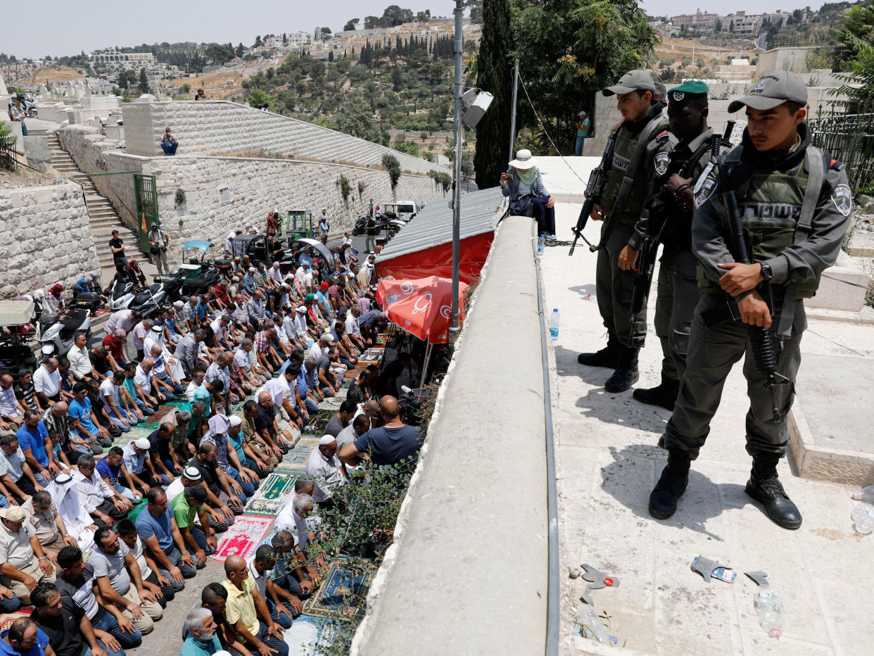 Israeli Border Police stand guard as Palestinian worshipers pray next to the Lions gate of the old city of Jerusalem: EPA