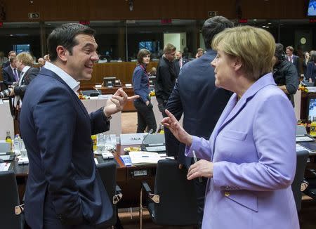 Greek Prime Minister Alexis Tsipras (L) talks with German Chancellor Angela Merkel at a European Union leaders summit in Brussels, Belgium, June 25, 2015. REUTERS/Yves Herman