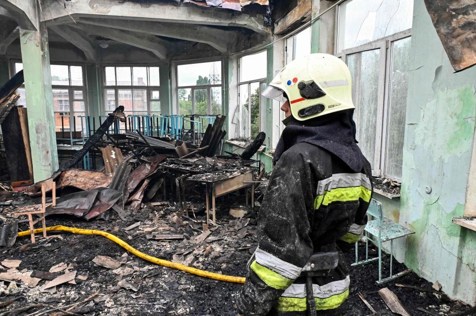 A firefighter inspects a damaged building of a vocational school after a missile strike in the Ukrainian city of Kharkiv, on July 30, 2022, amid the Russian invasion of Ukraine.