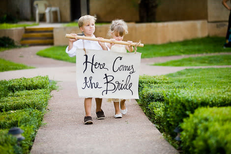 Pillow boy and flower girl carrying sign.