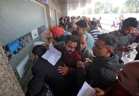 Passengers crowd a ticket counter outside the airport after their flight was cancelled following temporarily suspension of flights, in Jammu February 27, 2019. REUTERS/Mukesh Gupta