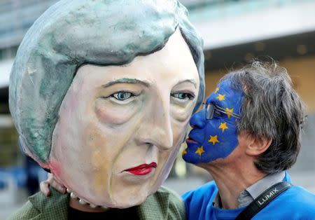 An anti-Brexit demonstrator kisses a protester dressed as Britain's Prime Minister Theresa May ahead of a EU Summit in Brussels, Belgium March 21, 2019. REUTERS/Yves Herman