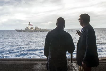 U.S. Secretary of Defense Ash Carter (R) speaks with U.S. Navy Cmdr. Robert C. Francis Jr., as Carter and Malaysian Defense Minister Hishammuddin Hussein (Not Pictured) visited the USS Theodore Roosevelt aircraft carrier in the South China Sea, in this handout photograph taken and released on November 5, 2015. REUTERS/Senior Master Sgt. Adrian Cadiz/Department of Defense/Handout