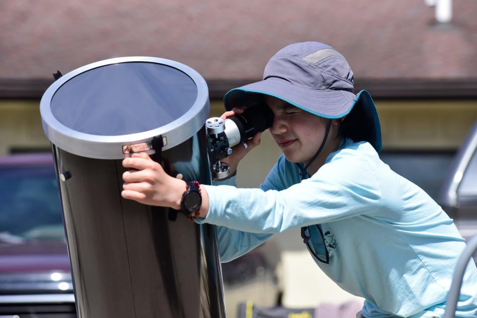 Saber Ferguson, 13, of San Francisco, peers through an Orion telescope equipped with a solar filter about 1:30 p.m. Monday at the Lowe-Volk Nature Center in Crawford County.