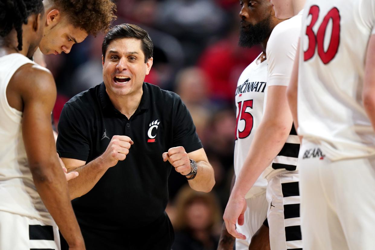 Cincinnati Bearcats head coach Wes Miller talks with the team during a timeout in the overtime period of a college basketball game between the TCU Horned Frogs and the Cincinnati Bearcats, Tuesday, Jan. 16, 2024, at Fifth Third Arena in Cincinnati. The Cincinnati Bearcats won, 81-77.