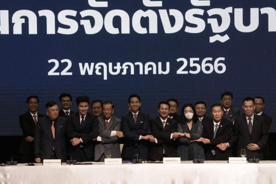 Leader of Move Forward Party Pita Limjaroenrat, front row fourth from left, holds hands after signing a memorandum of understanding on attempt to form a coalition government between Move Forward Party and other parties during a news conference in Bangkok, Thailand, Monday, May 22, 2023, Move Forward won the most seats in the May 14 election, and it has formed a coalition that seeks to become the government when Parliament selects a prime minister in July. (AP Photo/Sakchai Lalit)