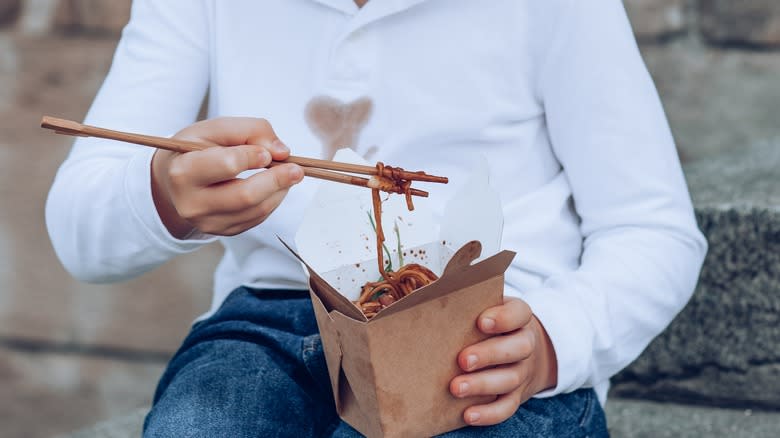 eating noodles with stained shirt