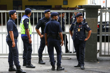 Malaysian police officers gather in front of the gate of the morgue at Kuala Lumpur General Hospital where Kim Jong Nam's body is held for autopsy in Malaysia February 21, 2017. REUTERS/Athit Perawongmetha