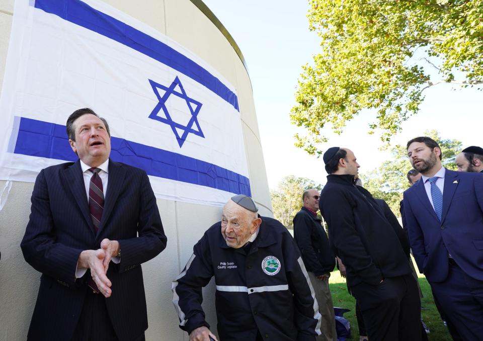 Ramapo Superviror Michael Specht, left, with county legislator Philip Soskin stand under the flag of Israel affixed on the front of the Ramapo Town Hall in Airmont after a ceremony on Thursday, October 12, 2023.