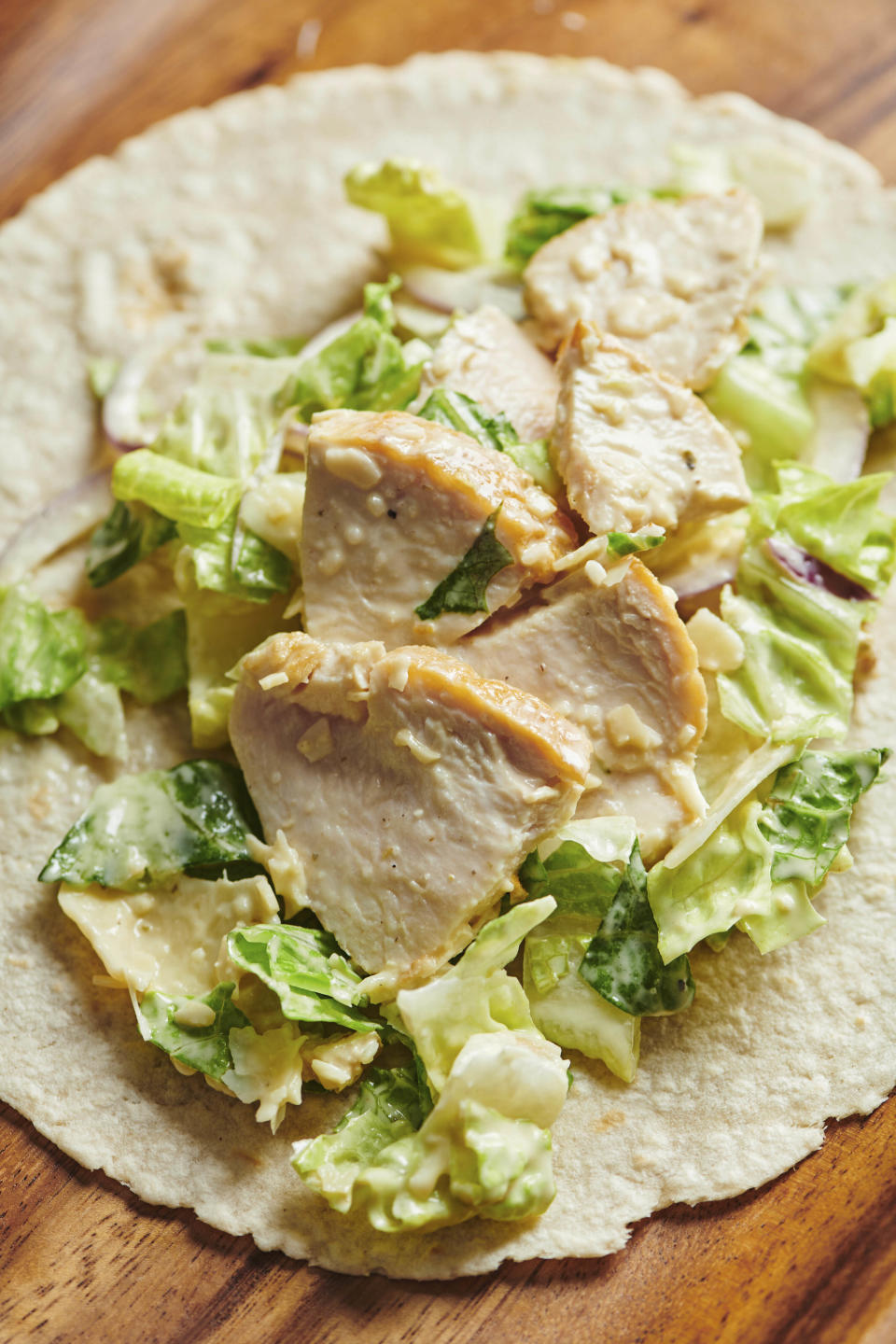 These photos show a recipe for chicken caesar wrap in New York in March 2019. There is little debate that the sandwich is the mainstay of most kids’ lunches but wraps have also taken their place in the pantheon of sandwich possibilities. (Cheyenne Cohen via AP)