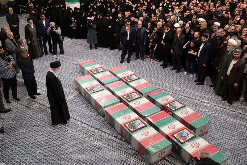 Iranian Supreme Leader Ayatollah Ali Khamenei (L) stands next to the coffins of seven Revolutionary Guard Corps members who were killed in a strike on the country's consular in Damascus, which Tehran blamed on Israel, ahead of their funeral procession. -/Iranian Supreme leader's Office/dpa