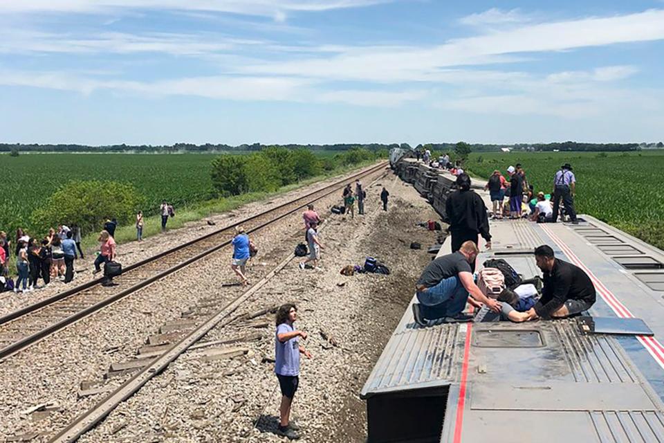 In this photo provided by Dax McDonald, an Amtrak passenger train lies on its side after derailing near Mendon, Mo., on Monday.