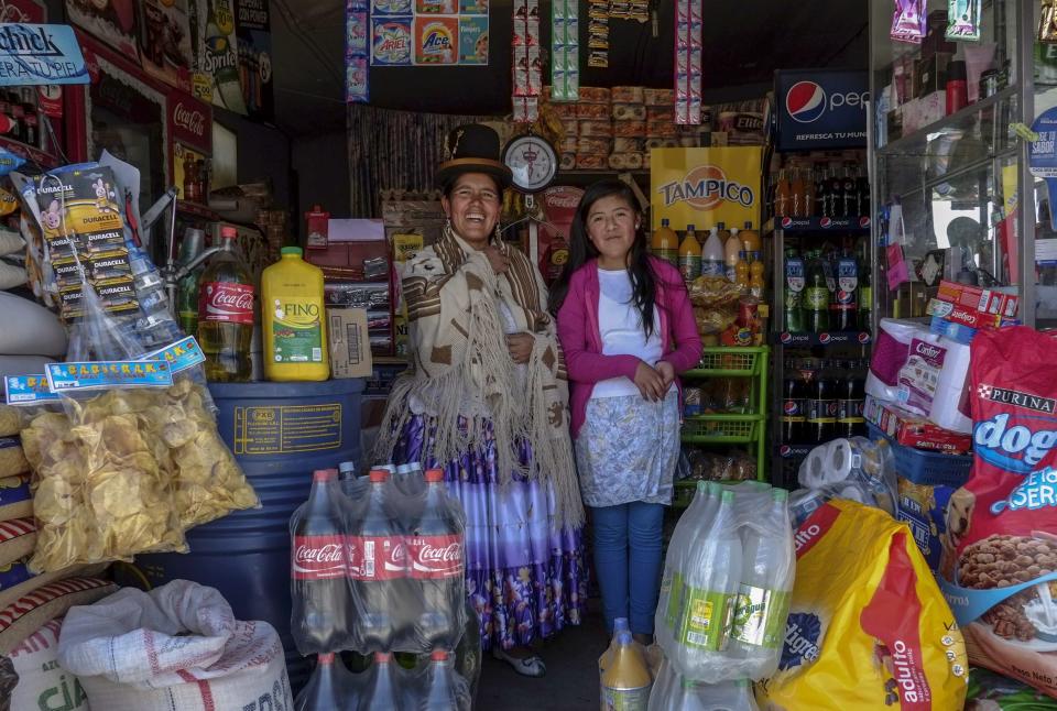Lucia Mayta and her daughter Luz Cecilia pose for a photograph inside their bodega in La Paz