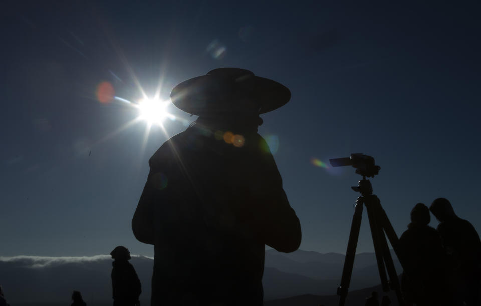 People watch a total solar eclipse in La Higuera, Chile, Tuesday, July 2, 2019. Northern Chile is known for clear skies and some of the largest, most powerful telescopes on Earth are being built in the area, turning the South American country into a global astronomy hub. (AP Photo/Esteban Felix)