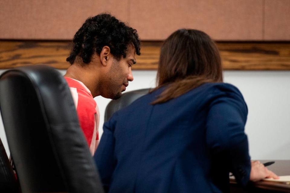 Denilson Marcus Elligson, 27, tears up as his attorney speaks to him during a probable cause hearing at Harrison County Court in Gulfport on Tuesday, June 25, 2024. Elligson is accused of capital murder and child abuse in the death of his infant son.