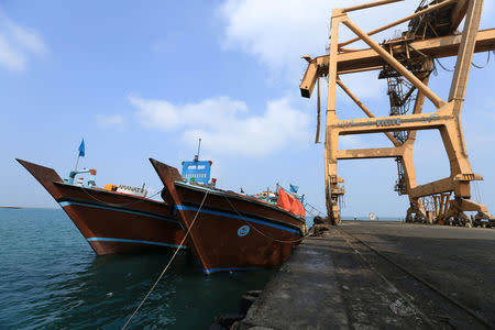 Boats are docked under cranes damaged by air strikes at the port of Hodeida, Yemen April 1, 2018. Oicture taken April 1, 2018. REUTERS/Abduljabbar Zeyad