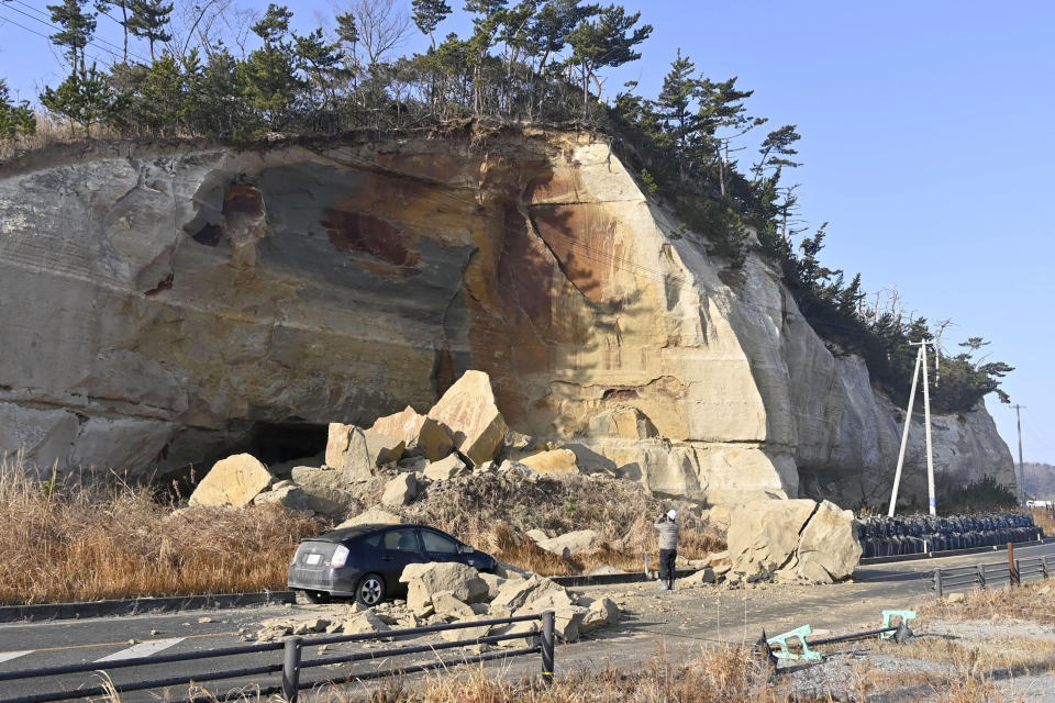 Collapsed rocks block a road after a strong earthquake hit Soma city, Fukushima prefecture, northeastern Japan, Sunday, Feb. 14, 2021. The strong earthquake shook the quake-prone areas of Fukushima and Miyagi prefectures late Saturday, setting off landslides and causing power blackouts for thousands of people. (Yohei Nishimura/Kyodo News via AP)