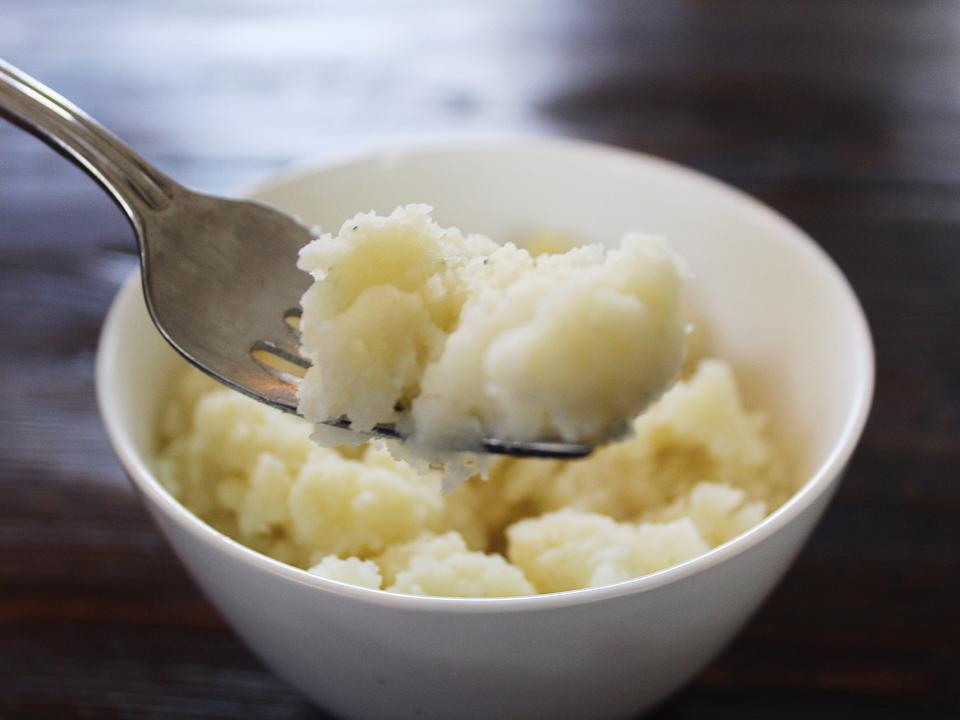 idahoan roasted garlic mashed potatoes in a white bowl with fork