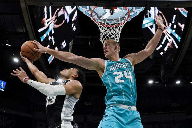 Charlotte Hornets center Mason Plumlee blocks a shot by San Antonio Spurs guard Tre Jones during the second half of an NBA basketball game on Saturday, March 5, 2022, in Charlotte, N.C. (AP Photo/Chris Carlson)