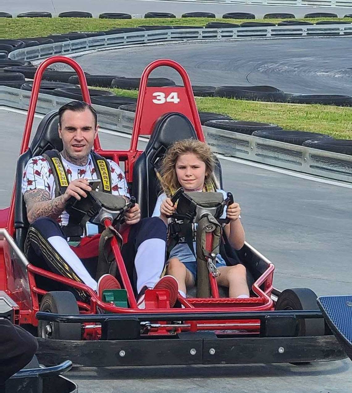 Brandon Combs rides around a Charlotte-area amusement park with his daughter, Allison, last summer. Combs was shot and killed by Concord police officers in February 2022 during a suspected theft at an auto dealership.