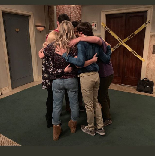 A photo of the cast of The Big Bang Theory hugging on set.