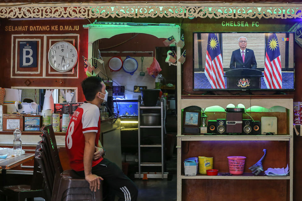 People watch a live telecast of Prime Minister Datuk Seri Ismail Sabri Yaakob’s speech at a restaurant in Kuala Lumpur August 22, 2021. — Picture by Yusof Mat Isa