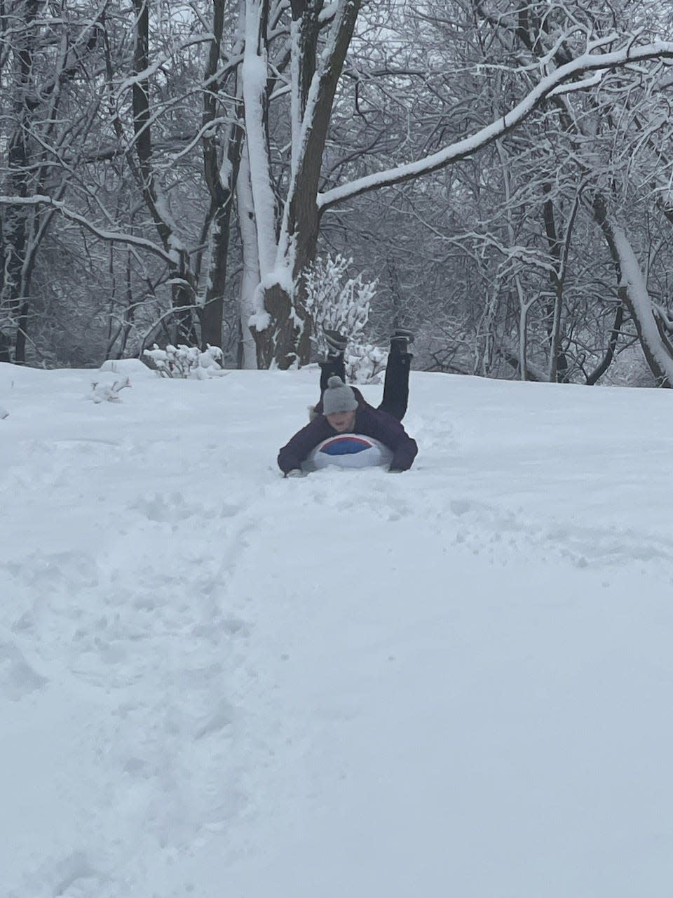 Harper Walters, 10, of Lincoln Park, sledding down a hill.