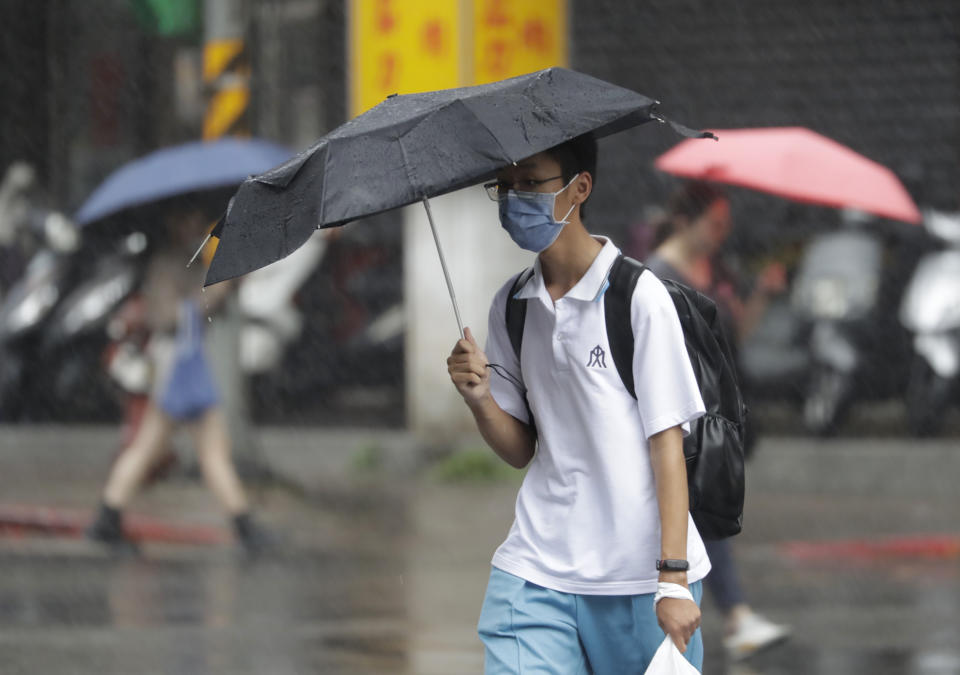 People walk in the rain as Typhoon Koinu approaches to Taiwan in Taipei, Taiwan, Wednesday, Oct. 4, 2023. (AP Photo/Chiang Ying-ying)