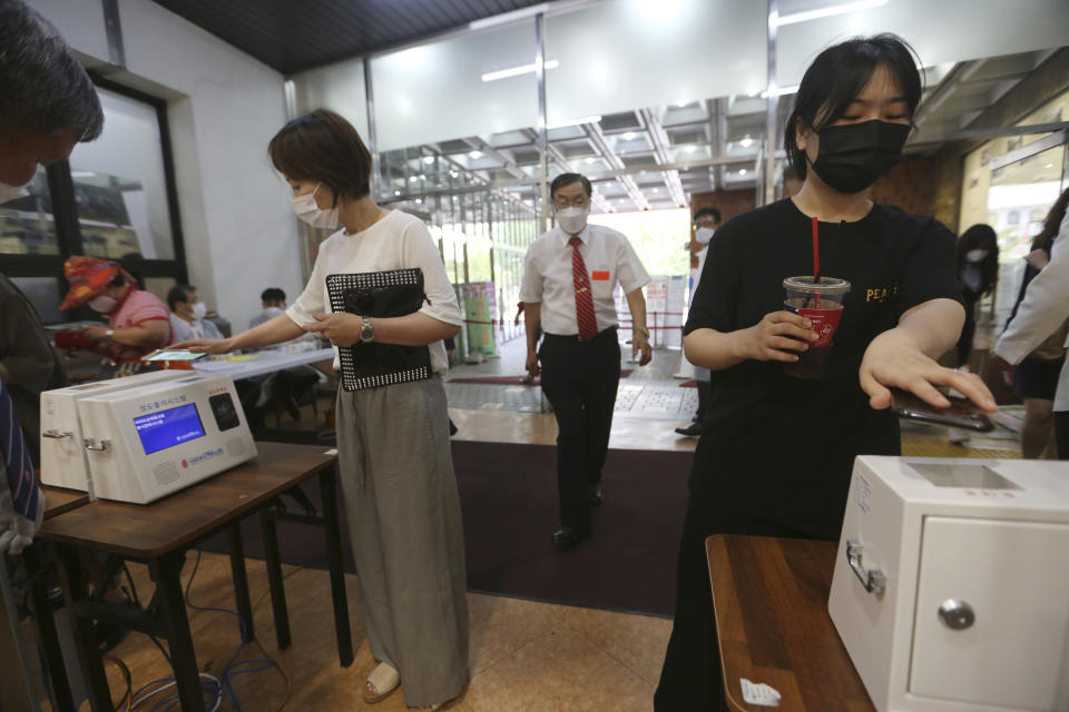 Christians wearing face masks to help protect against the spread of the new coronavirus scan QR codes on their smartphones before attending a service at the Yoido Full Gospel Church in Seoul, South Korea, Sunday, July 5, 2020. (AP Photo/Ahn Young-joon)