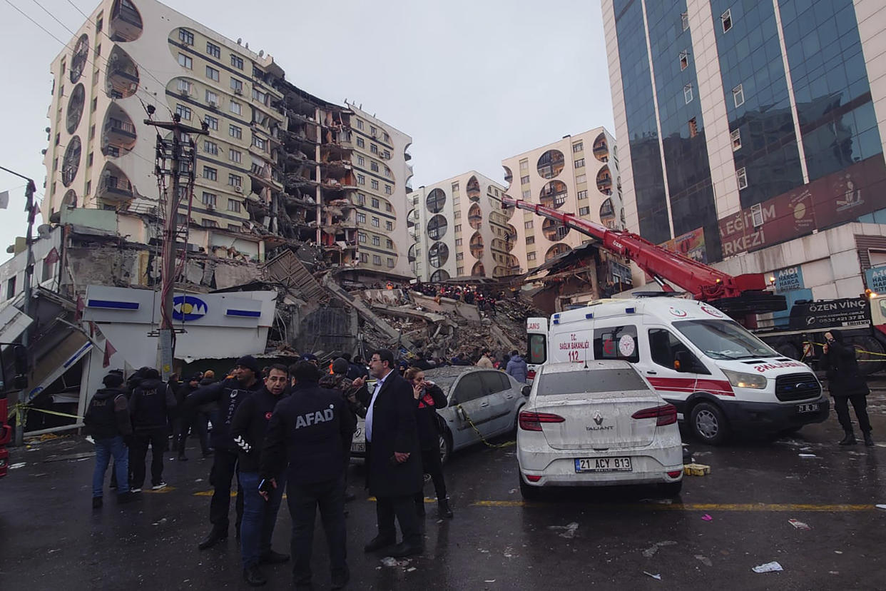 Rescue workers and medical teams try to reach trapped residents in a collapsed building following and earthquake in Diyarbakir, southeastern Turkey, early Monday, Feb. 6, 2023. A powerful earthquake has caused significant damage in southeast Turkey and Syria and many casualties are feared. Damage was reported across several Turkish provinces, and rescue teams were being sent from around the country. (AP Photo/Mahmut Bozarsan)