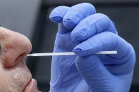 FILE - In this June 12, 2020 file photo, a nurse uses a swab to perform a coronavirus test in Salt Lake City. On Friday, Sept. 24 The Associated Press reported on stories circulating online questioning why an invasive nasal is necessary if COVID-19 spreads so easily through droplets. The answer is simple: nasal swabs allow for a sample to be taken where the respiratory virus lives. The coronavirus death toll in the U.S. surpassed 200,000 this week. (AP Photo/Rick Bowmer, File)