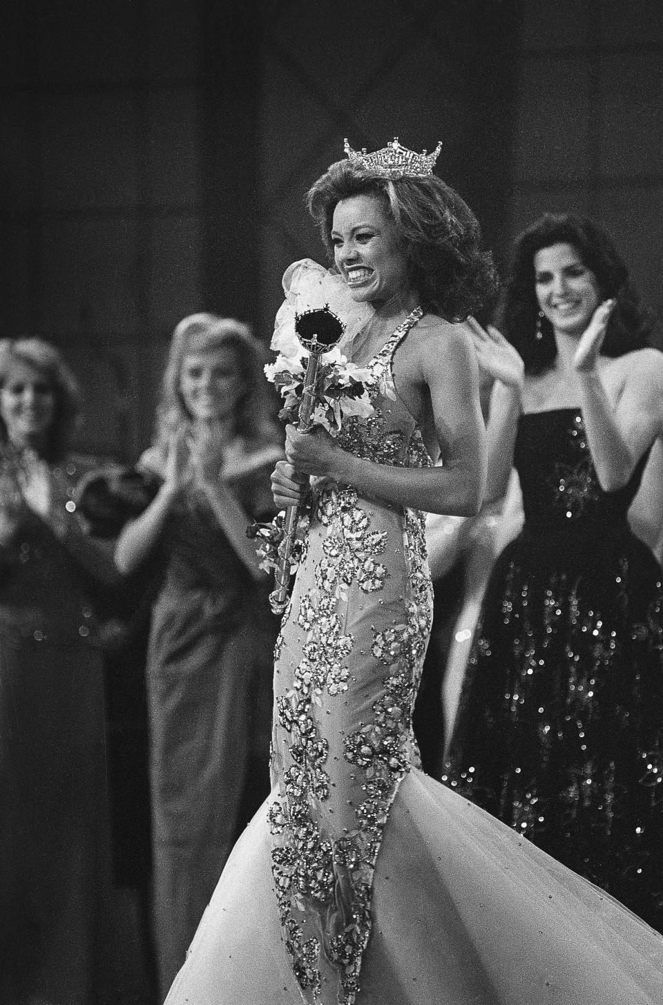 Crowned the new Miss America 1984, Miss New York, Vanessa L. Williams beams as she is applauded by runners-up Miss Virginia, Lisa Aliff (left), and Miss Ohio, Pamela Rigas (right). Williams is the first black woman to have won the crown in the pageant's 63-year history.