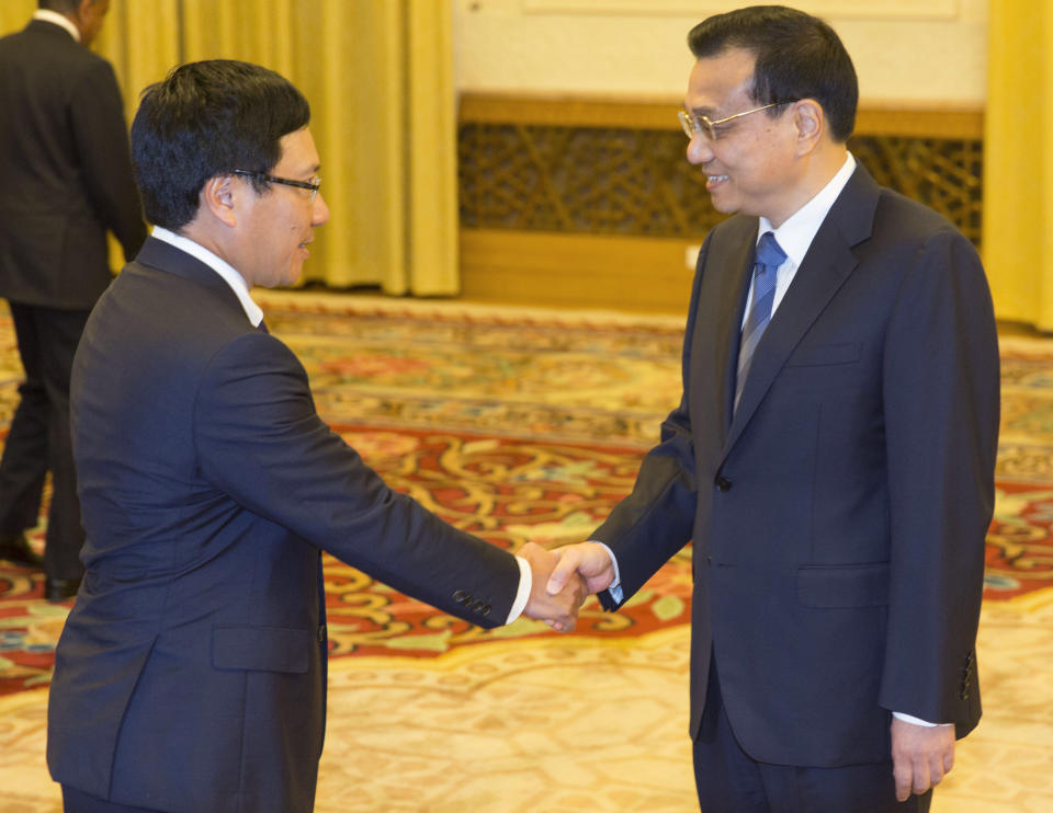 FILE - In this Aug. 29, 2013 file photo, Chinese Premier Li Keqiang, right, meets with Vietnam Foreign Minister Pham Binh Minh at the Great Hall of the People in Beijing as 12 ASEAN foreign ministers are in the Chinese capital to attend the ASEAN-China foreign ministers meeting which aims to discuss economic ties as well as regional concerns such as disputed territory in the South China sea. Vietnam demanded China stop oil drilling operations in a disputed patch of the South China Sea, saying on Monday, May 5, 2014 that Beijing's decision to deploy a deep sea rig over the weekend was illegal. China dismissed the objections, saying the activity was being carried out in its territorial waters. (AP Photo/Adrian Bradshaw, Pool, File)