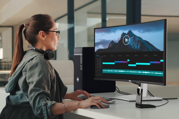 A woman using a 38-inch ultrawide Dell monitor.