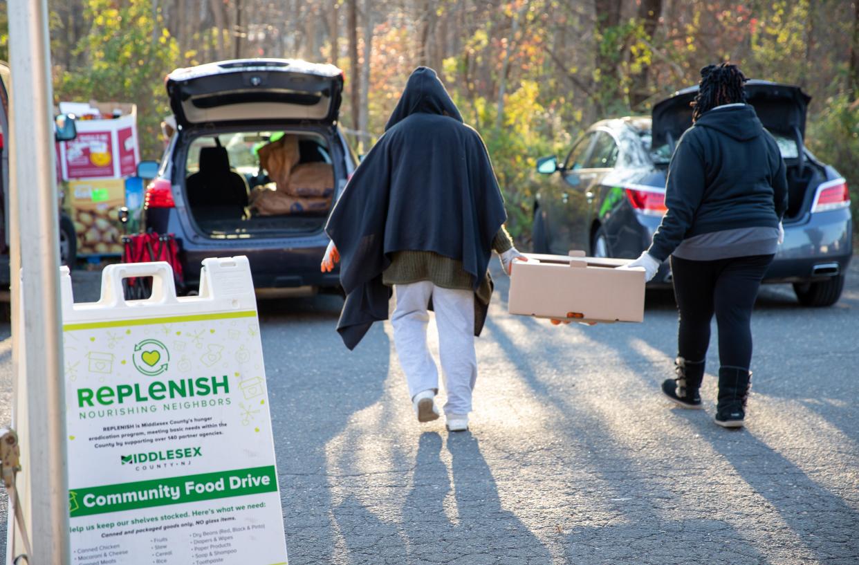 Volunteers help the REPLENISH team load food into vehicles.