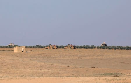 A Turkish flag flutters on a military vehicle on the border of Manbij city