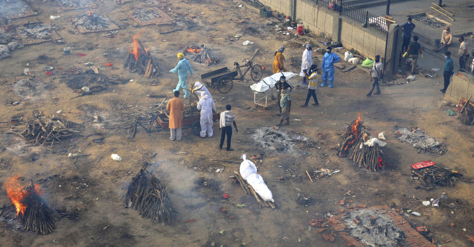 Multiple funeral pyres of those patients who died of COVID-19 disease are seen burning at a ground that has been converted into a crematorium for mass cremation of coronavirus victims, in New Delhi, India, Wednesday, April 21, 2021. (AP Photo)