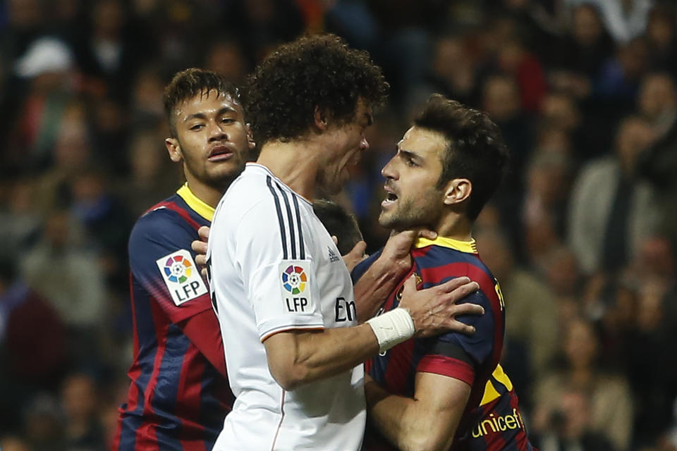 Real's Pepe, centre, reacts with Barcelona's Cesc Fabregas, centre right, as Fabregas celebrates Lionel Messi's goal, during a Spanish La Liga soccer match between Real Madrid and FC Barcelona at the Santiago Bernabeu stadium in Madrid, Spain, Sunday, March 23, 2014. (AP Photo/Andres Kudacki)