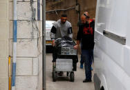 An undercover Israeli security officer pushes a trolley containing documents and a computer hard-drive seized from a Palestinian map office by Israeli security officers as they carry out an Israeli police order to close the office, in the Arab East Jerusalem neighbourhood of Beit Hanina March 14, 2017. REUTERS/Ammar Awad