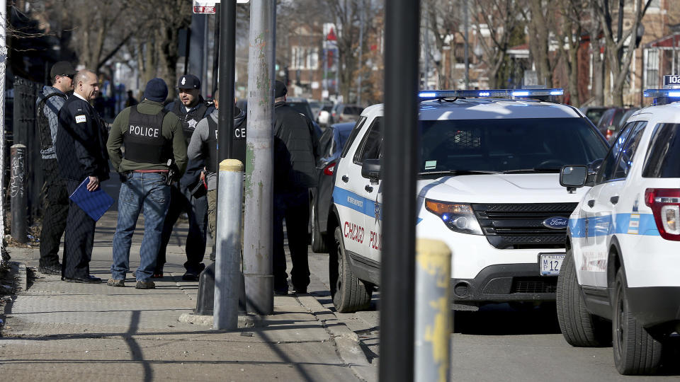 Chicago police stand near where a toddler and a man were fatally shot and a woman was wounded near Ogden and Kostner avenues in the Little Village neighborhood of Chicago Tuesday, Feb. 14, 2017. Police are examining dramatic video that captured the shooting that killed a toddler and a man authorities say was the intended target. (Terrence Antonio James/Chicago Tribune via AP)/Chicago Tribune via AP)