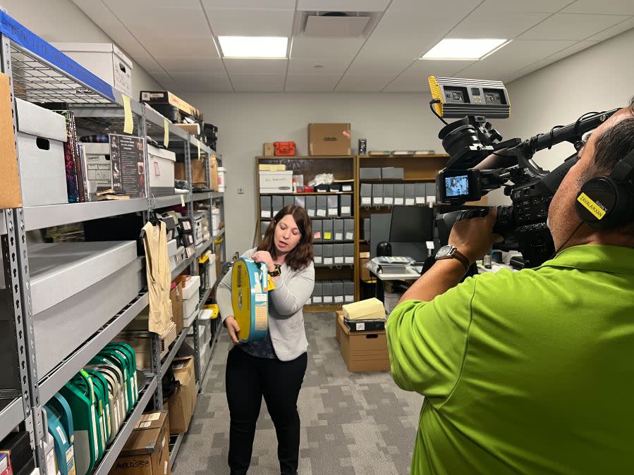 Liz Antaramian, Director of Archives at Austin PBS, holds a copy of the first taping of the Austin City Limits TV show, featuring a performance by Willie Nelson (KXAN Photo/Abigail Jones)