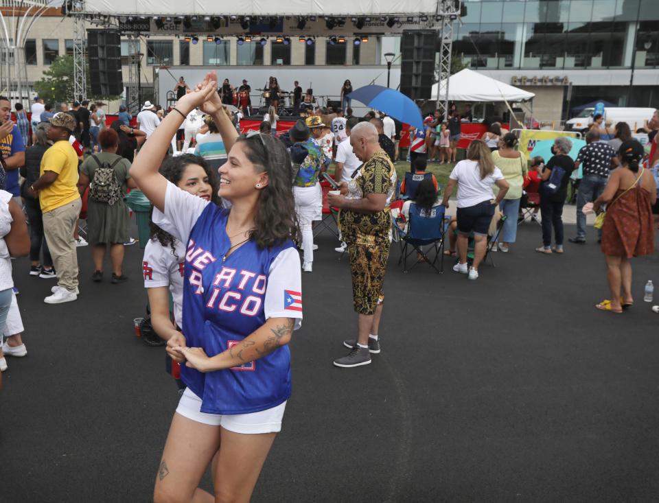 Alina Figueroa, back left, and Ashley M. Rivera, front right, both of Rochester, dance the afternoon away to the live music of Sonidos Unidos during the final day of the Puerto Rican Festival held at Parcel 5 in downtown Rochester Saturday, August 21, 2021. 