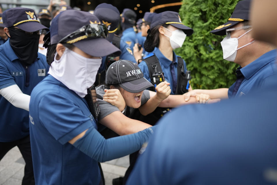 South Korean students are detained by police officers as they attempt to enter to Japanese Embassy to protest denouncing to release treated radioactive water into the sea from the damaged Fukushima nuclear power plant, at a building which houses Japanese Embassy, in Seoul, South Korea, Thursday, Aug. 24, 2023. The operator of the tsunami-wrecked Fukushima Daiichi nuclear power plant says it has begun releasing its first batch of treated radioactive water into the Pacific Ocean — a controversial step, but a milestone for Japan's battle with the growing radioactive water stockpile. (AP Photo/Lee Jin-man)