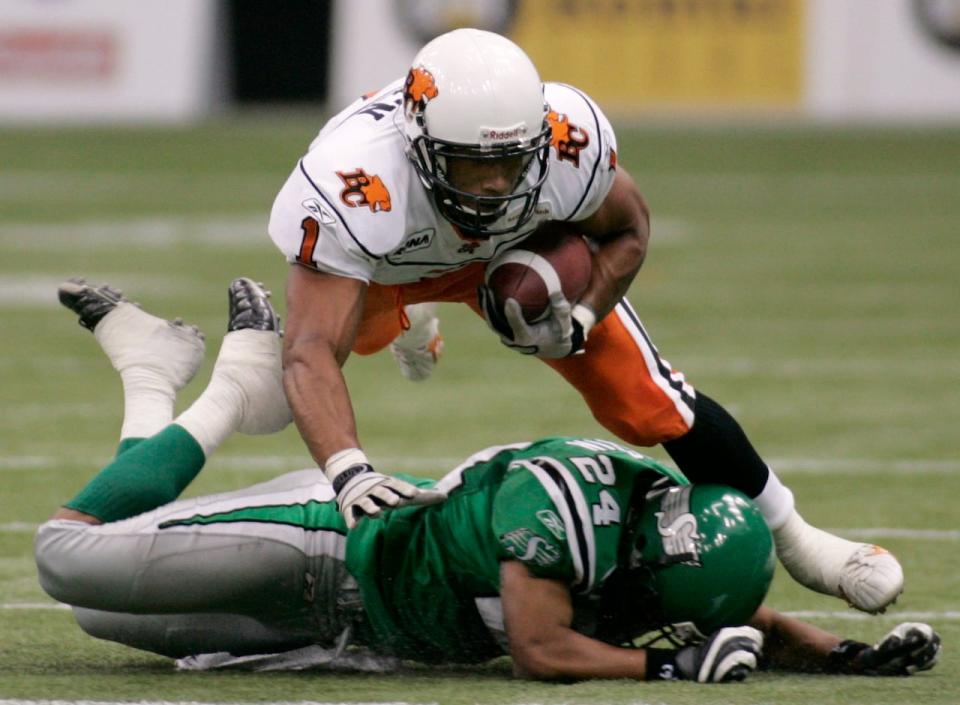 B.C. Lions Josh Boden (1) is tripped up by Saskatchewan Roughriders Airibin Justin (24) after catching a pass during pre-season CFL action in Vancouver on June 15, 2007. 