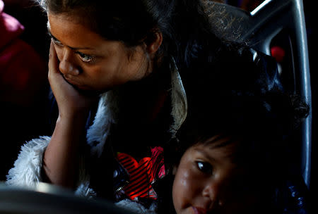 A migrant woman and a girl, part of a caravan of thousands traveling from Central America en route to the United States, sit in a bus while the bus stop for them to get food and water from a store on a highway in Culiacan, Mexico November 15, 2018. REUTERS/Kim Kyung-Hoon